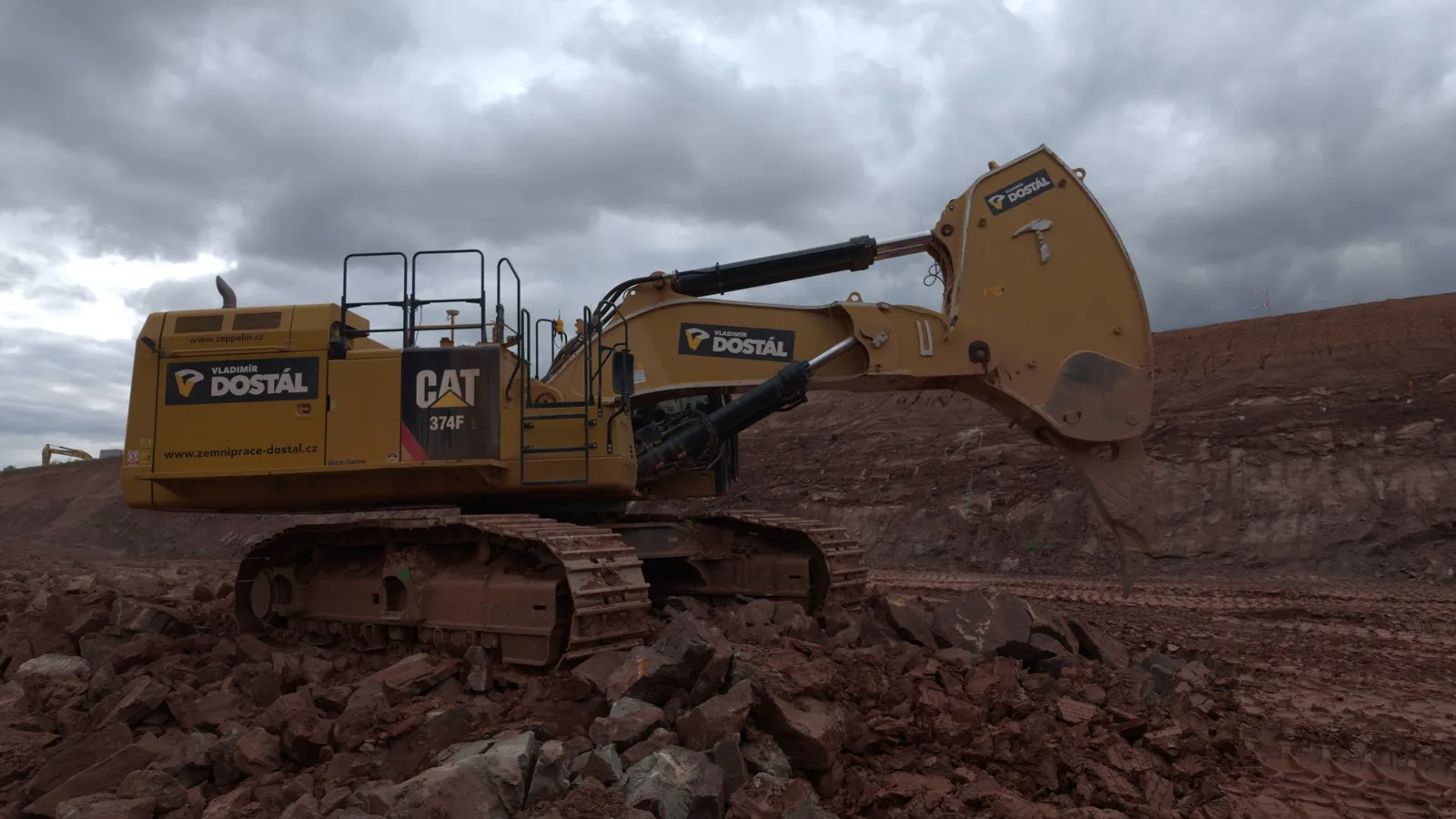 Bagr CAT 374F při těžbě horniny, stavba D11 pro Zemní práce Dostál